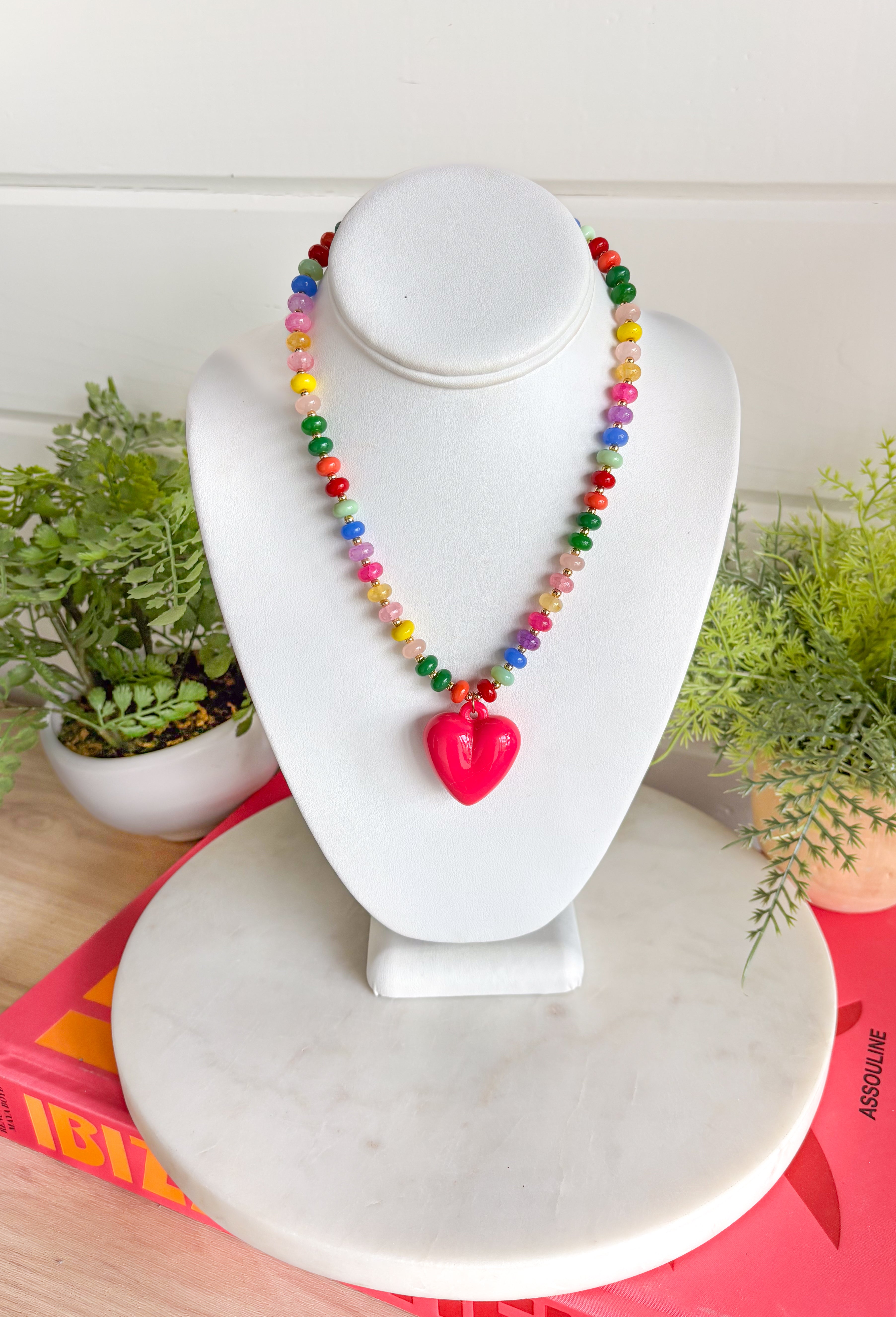 Bright, playful, and full of personality! This colorful beaded necklace is the perfect piece to add a little happiness to your look. Featuring a mix of vibrant beads and a bold hot pink pendant charm, it brings a fun pop of color that instantly livens up any outfit.&nbsp;The adjustable chain makes it easy to style at different lengths, whether worn on its own or layered with other favorites. Cheerful and eye-catching, this necklace is a simple way to add a little joy to your everyday style.