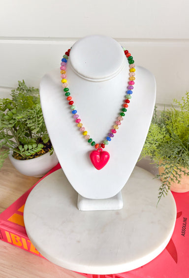Bright, playful, and full of personality! This colorful beaded necklace is the perfect piece to add a little happiness to your look. Featuring a mix of vibrant beads and a bold hot pink pendant charm, it brings a fun pop of color that instantly livens up any outfit.&nbsp;The adjustable chain makes it easy to style at different lengths, whether worn on its own or layered with other favorites. Cheerful and eye-catching, this necklace is a simple way to add a little joy to your everyday style.
