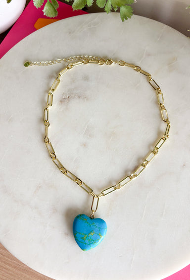 A bold little pop of color with a touch of charm. This eye-catching necklace features a turquoise heart pendant with beautiful green marbling, creating a unique stone look that instantly stands out. The vibrant heart is suspended from a chic gold paperclip chain for a modern, stylish feel. Designed to be versatile, this piece looks just as stunning worn on its own as it does layered with your favorite gold chains. 