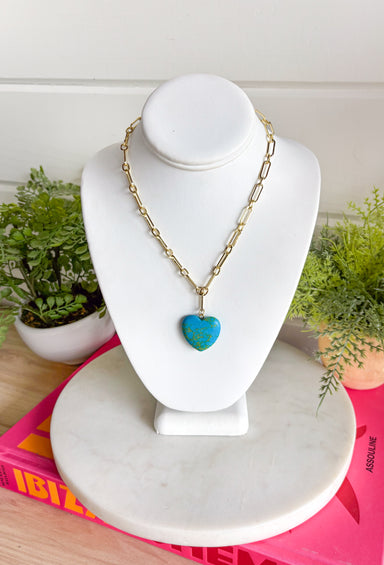 A bold little pop of color with a touch of charm. This eye-catching necklace features a turquoise heart pendant with beautiful green marbling, creating a unique stone look that instantly stands out. The vibrant heart is suspended from a chic gold paperclip chain for a modern, stylish feel. Designed to be versatile, this piece looks just as stunning worn on its own as it does layered with your favorite gold chains. 