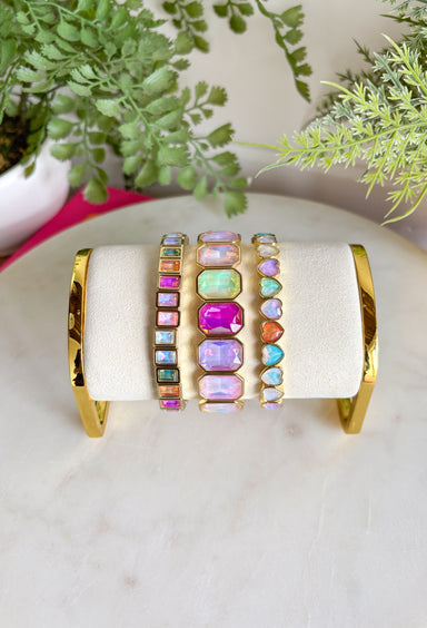 Soft sparkle with a romantic touch! This set of three bracelets features a beautiful mix of gold-tone bands, delicate crystal accents, and sweet pastel heart details for a look that feels feminine and timeless. Designed as stretch bracelets, they’re easy to slip on and comfortable for everyday wear. The gold-plated finish adds a polished shine, while the pastel tones bring a soft pop of color that’s perfect for layering. Wear all three together for a pretty stacked look or mix them with your favorite pieces