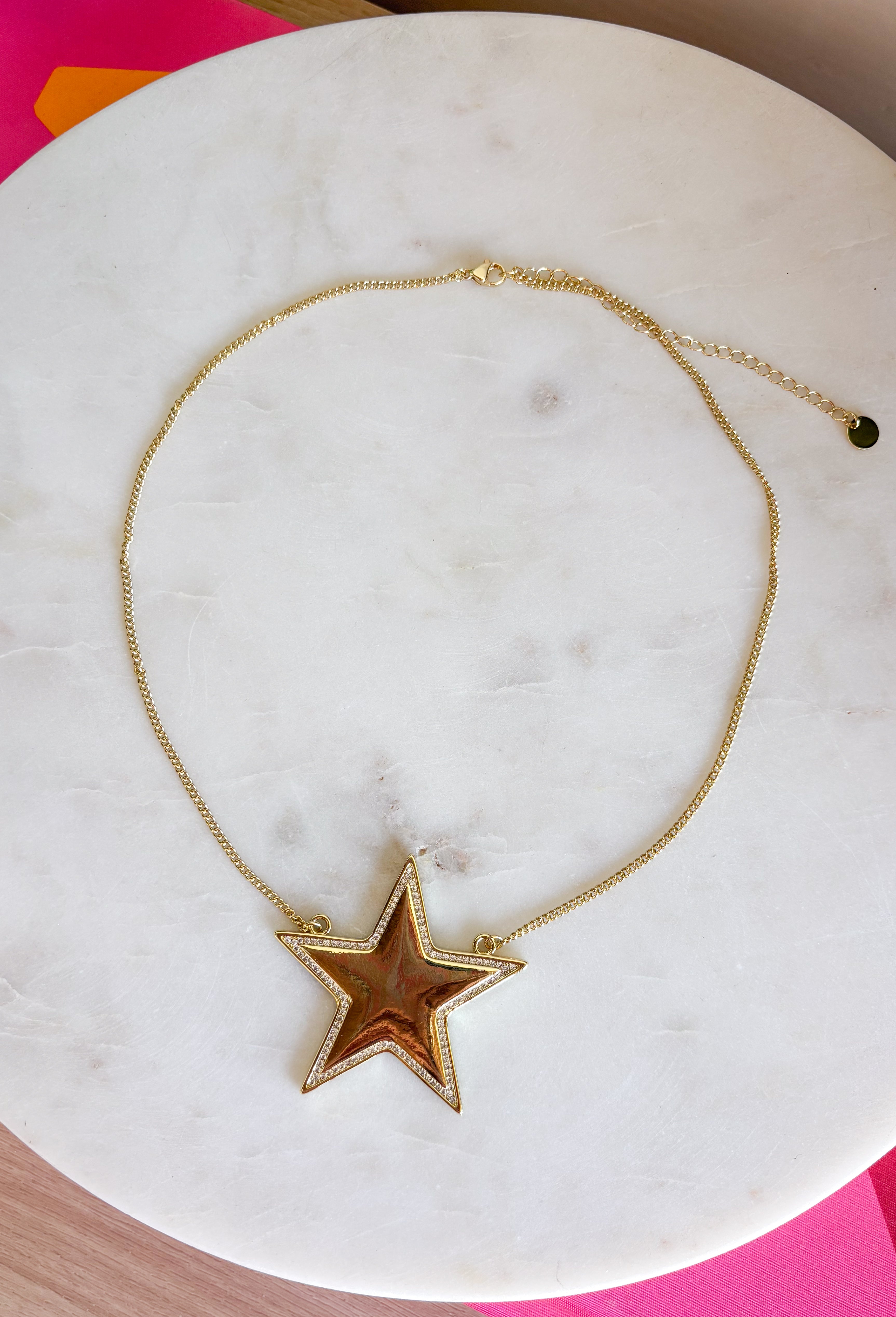 Add a little sparkle to every outfit with this stunning star pendant necklace! Featuring a bold gold star framed by delicate crystal accents, this handcrafted piece is the perfect blend of timeless elegance and modern charm. Whether you're dressing up for a special occasion or adding a little shine to your everyday look, this eye-catching necklace is designed to stand out while remaining effortlessly wearable.