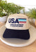 This neutral trucker hat is the perfect laid-back statement for everyday wear. Featuring “USA Home of Cowboys &amp; Country Music” embroidered in navy with colorful stitched accents, it adds a fun pop of detail while keeping things classic and easy to style. The neutral base makes it an effortless match with just about anything, and the adjustable back ensures a comfortable, just-right fit. Whether you’re running errands, heading to a concert, or finishing off a casual outfit, this hat brings a little perso