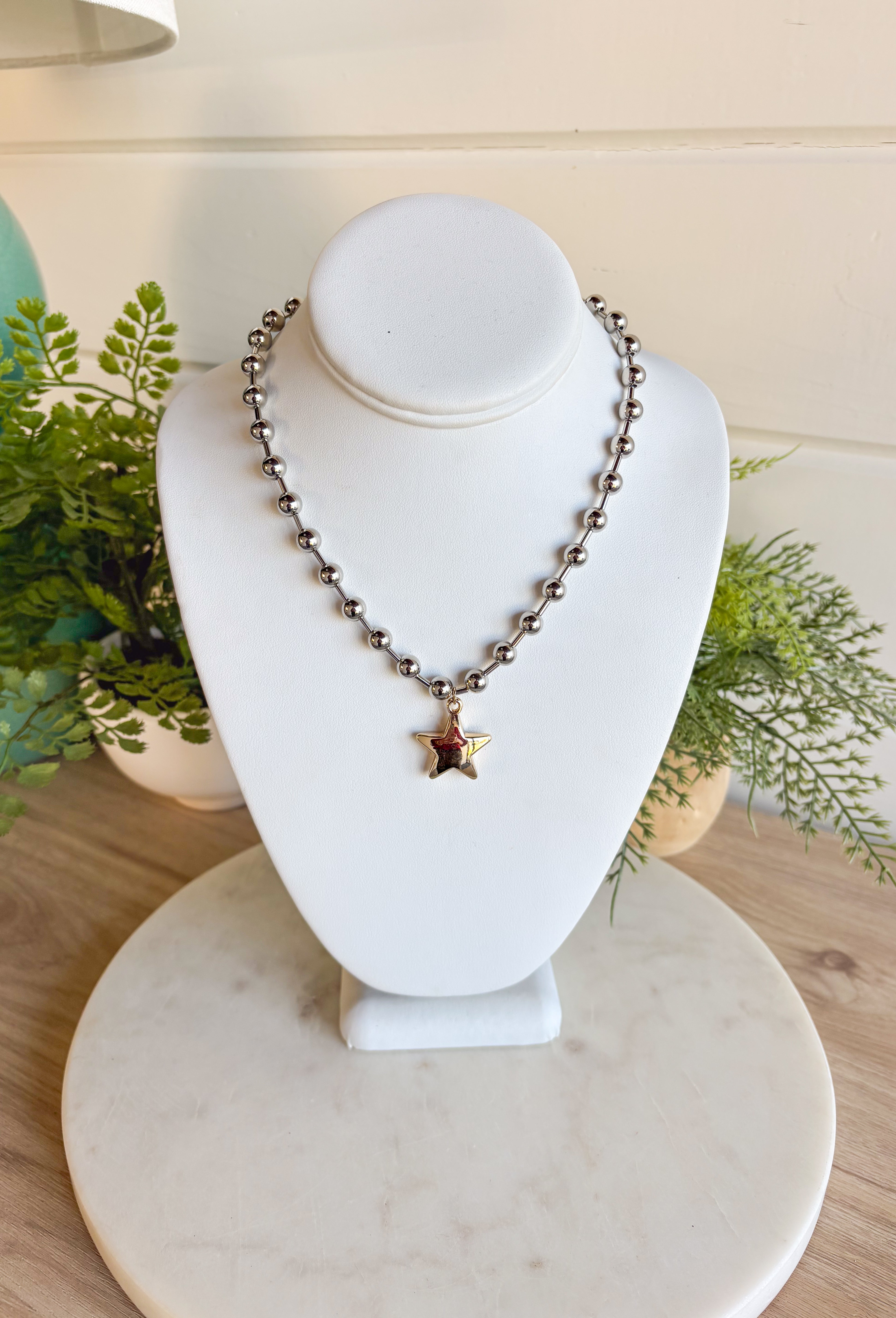 A versatile piece with just the right amount of presence—this silver beaded necklace is finished with a gold star charm that adds a modern, stylish touch. The beaded texture gives it a little extra dimension, making it stand out whether worn solo or layered with other chains. With a lobster clasp and extender, it adjusts easily for the perfect fit, making it an effortless accessory for any outfit or occasion.