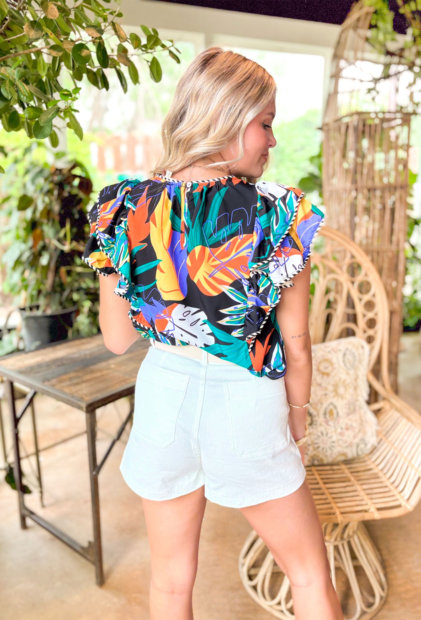 Eyes On Paradise Blouse, black ruffle sleeve blouse with black and white striped trimming and royal blue, orange, yellow, and green palm leaf print 