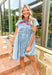 Heading West Denim Dress, acid washed denim babydoll button down dress with four little pleats on each front half of the dress and two front pockets with button closures 