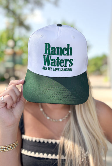 Charlie Southern: Ranch Water Trucker Hat, white and forest green baseball style trucker hat with forest green embroidered text "ranch waters are my love language" on the front of the trucker hat 