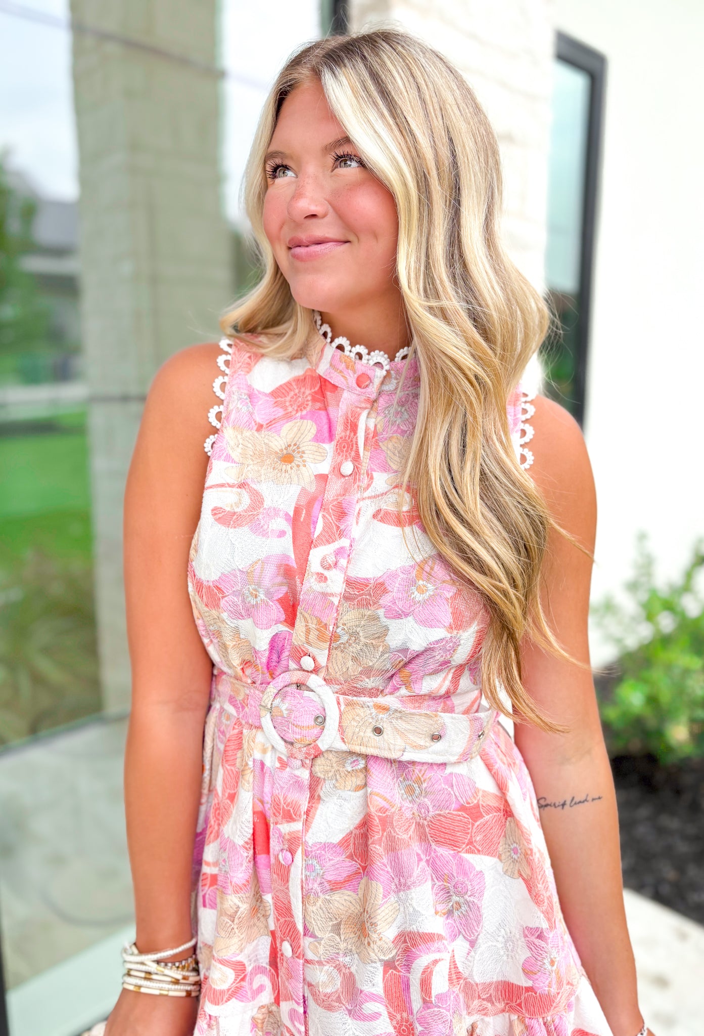 Sending Love Notes Floral Dress, pink, orange, red, yellow and off white sleeveless high-neck floral button down dress with white lace texture, white lace trimming on the arm holes and around the neck as well as a matching belt