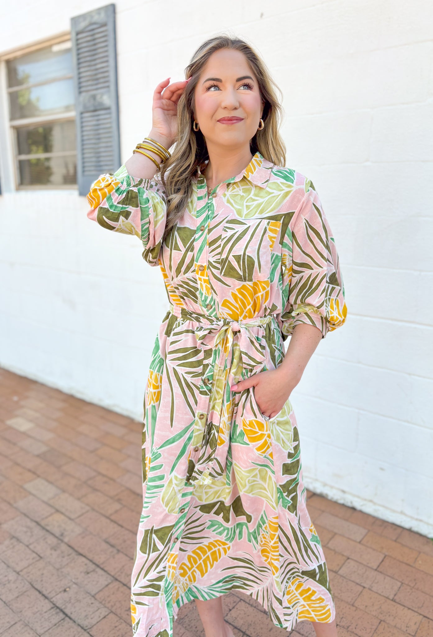 Set Me Free Midi Dress, quarter sleeve button down midi dress in a pale salmon color with sage green, amazon green and mustard yellow palm leaves printed across the dress, matching tie belt around the waist