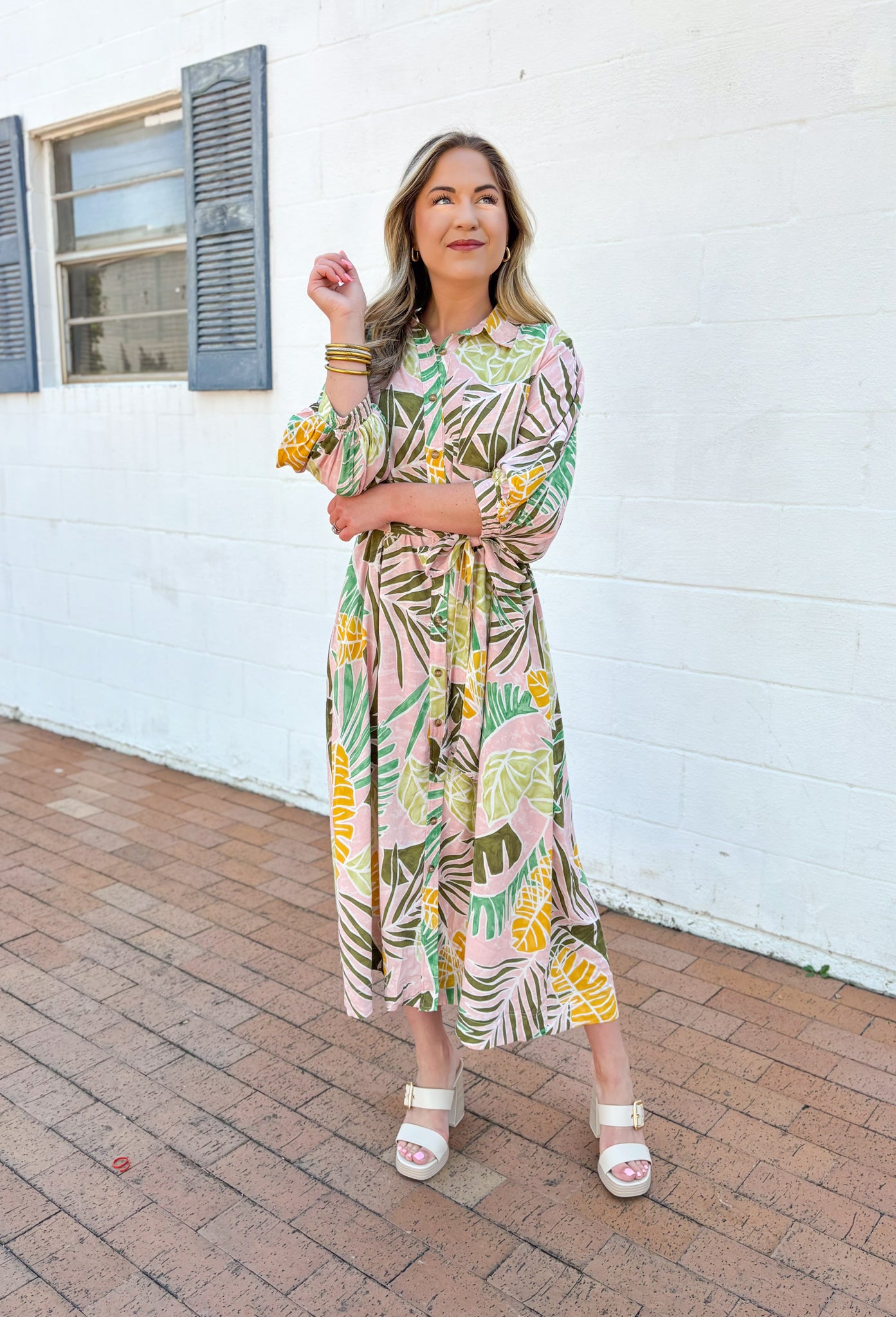 Set Me Free Midi Dress, quarter sleeve button down midi dress in a pale salmon color with sage green, amazon green and mustard yellow palm leaves printed across the dress, matching tie belt around the waist