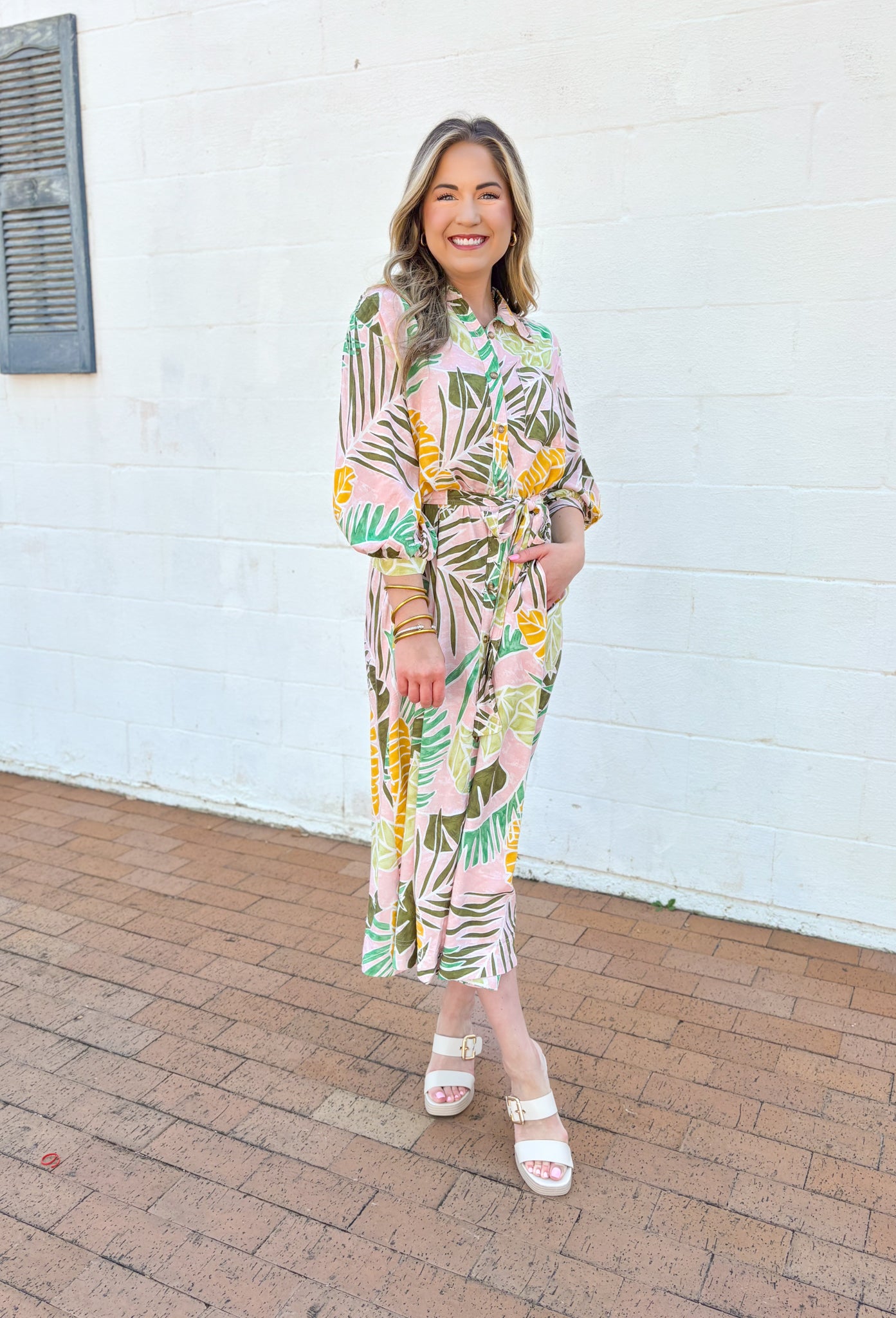 Set Me Free Midi Dress, quarter sleeve button down midi dress in a pale salmon color with sage green, amazon green and mustard yellow palm leaves printed across the dress, matching tie belt around the waist