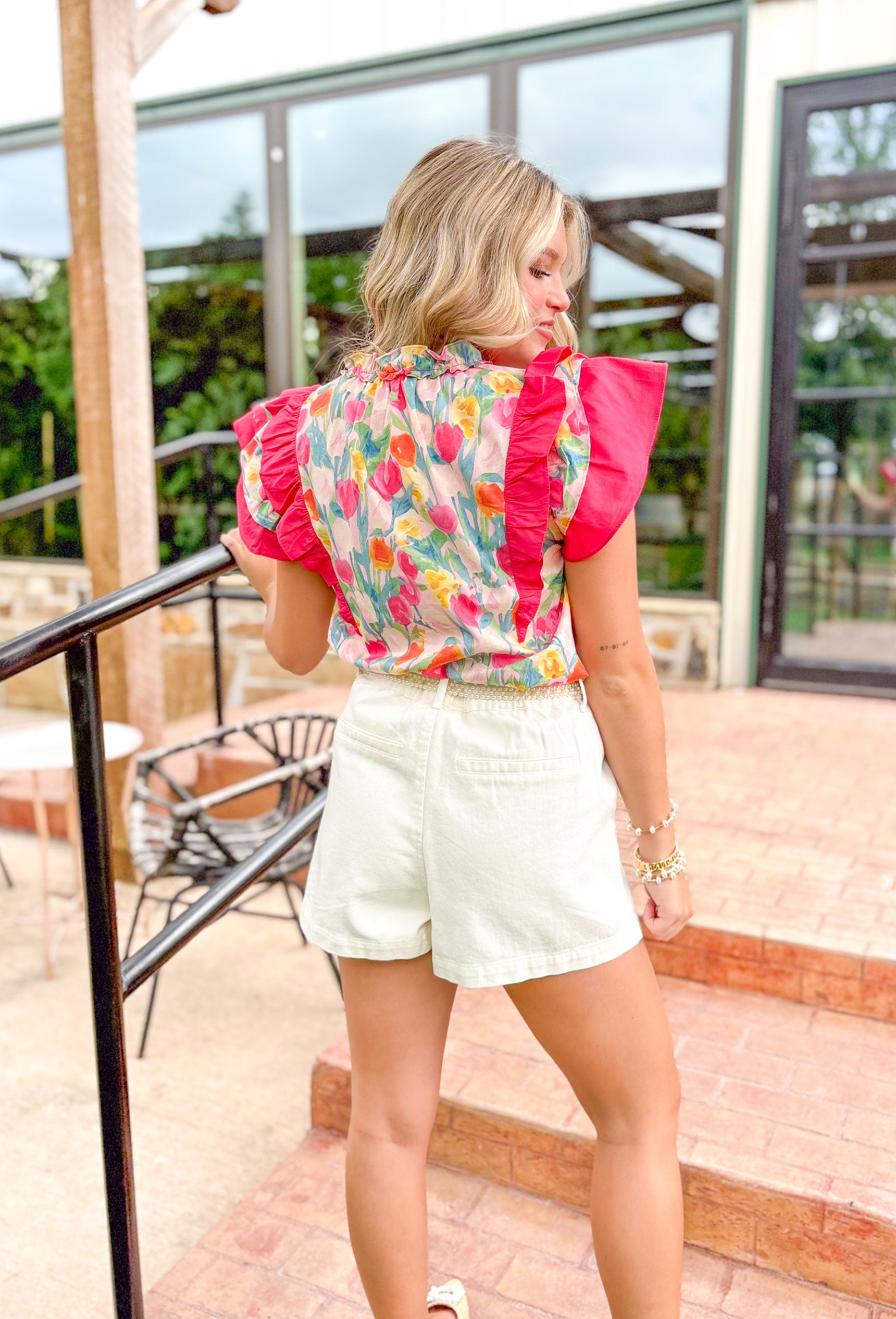 Sunny With A Chance Of Blooms Blouse, tulip printed ruffle sleeve blouse, hot pink ruffles on the sleeves, v-neck, tulips in aqua, hot pink, bubble gum pink, yellow, light pink, and cream