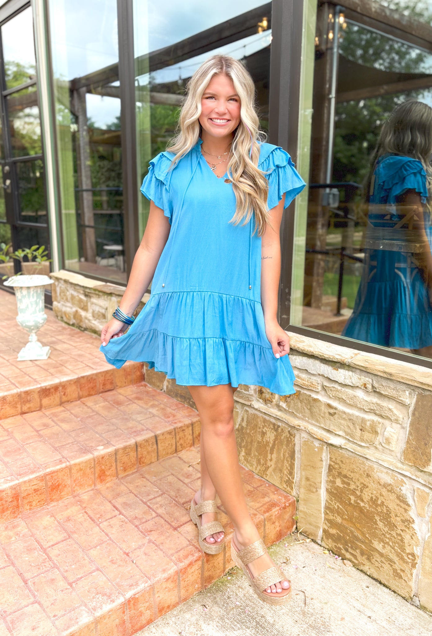 Weekends By The Coast Dress, bright blue v-neck ruffle sleeve tiered dress with string details and ruffling around the neck 
