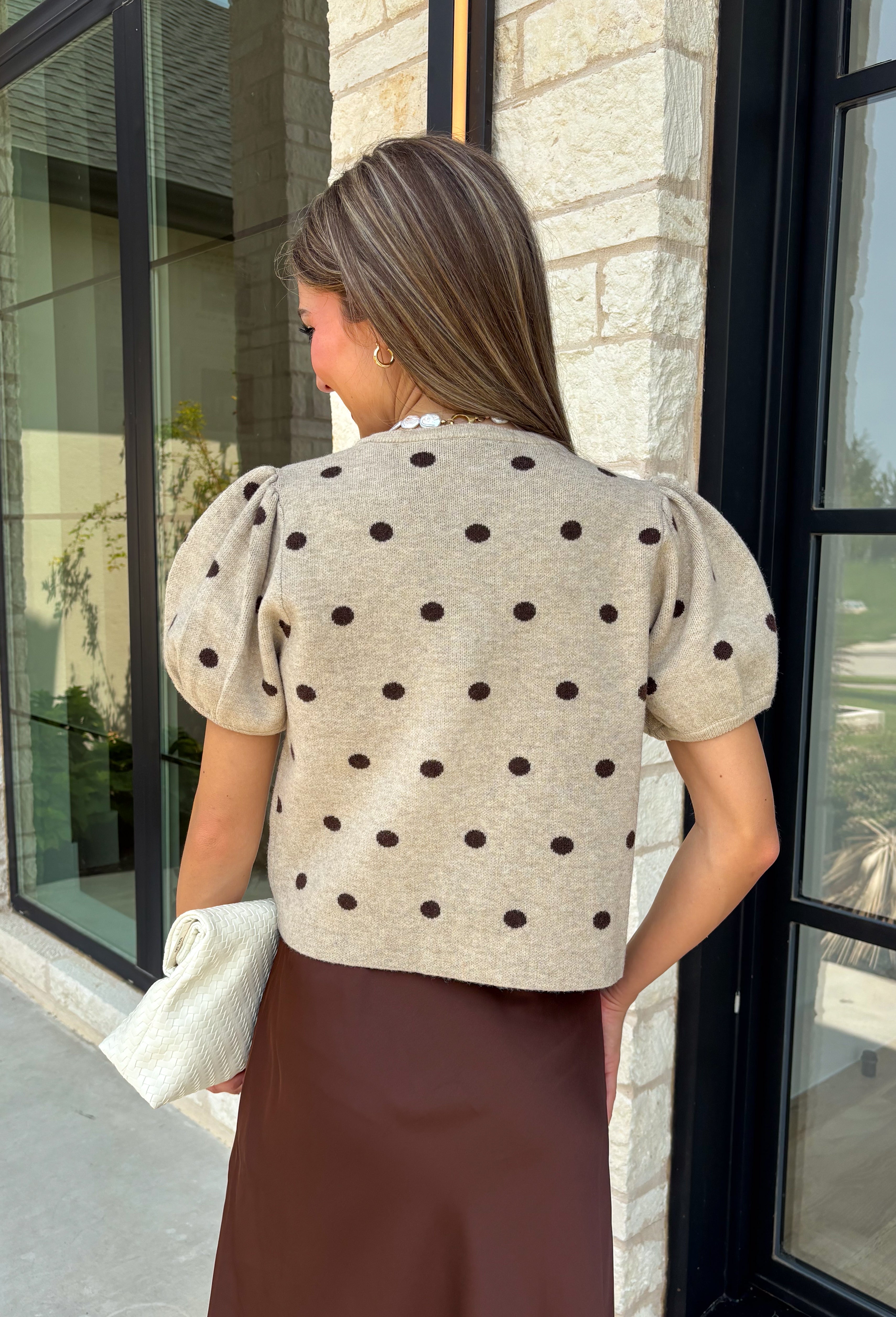 A classic print meets an effortlessly feminine silhouette in this charming knit cardigan! Featuring a soft tan knit with a playful brown polka dot print, this button-down cardigan is finished with sweet puff sleeves for an elevated touch. Whether worn buttoned as a top or layered over your favorite basics, this versatile piece is perfect for everything from office days to coffee dates and weekend outings.