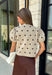 A classic print meets an effortlessly feminine silhouette in this charming knit cardigan! Featuring a soft tan knit with a playful brown polka dot print, this button-down cardigan is finished with sweet puff sleeves for an elevated touch. Whether worn buttoned as a top or layered over your favorite basics, this versatile piece is perfect for everything from office days to coffee dates and weekend outings.