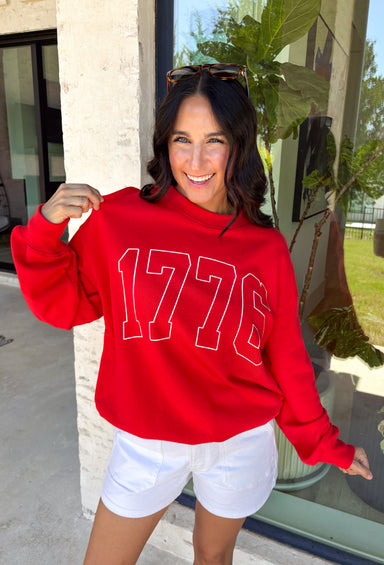 A timeless nod to American pride! This red pullover features “1776” in bold white lettering across the front, making it the perfect piece to celebrate Independence Day and beyond. Classic, patriotic, and easy to style, it’s a go-to for summer holidays, fireworks, and casual days. Made from soft 100% cotton, this pullover is comfortable and breathable while still giving you that cozy feel. 