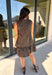 Leopard gets a refined update with this black and brown printed dress from Entro. The neutral color palette gives the statement print a classic feel, making it easy to wear for everything from dinner plans and work events to fall gatherings. A full button-down detail off centered adds an unexpected touch that sets this dress apart, while the sleeveless silhouette keeps the look clean and easy to layer. The tiered skirt adds movement and shape, and the fully lined design provides comfortable coverage.