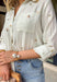 This off white button down is one of those effortlessly pretty pieces that works all summer long! The light olive stripe print paired with delicate floral embroidery gives it a soft, elevated feel while still being easy to style for everyday wear. Designed with a classic collared neckline, front pockets, and cuffed sleeves, it has that timeless button down look with a feminine twist. Lightweight and breathable, it’s perfect for layering over a tank or wearing on its own with denim or shorts. 