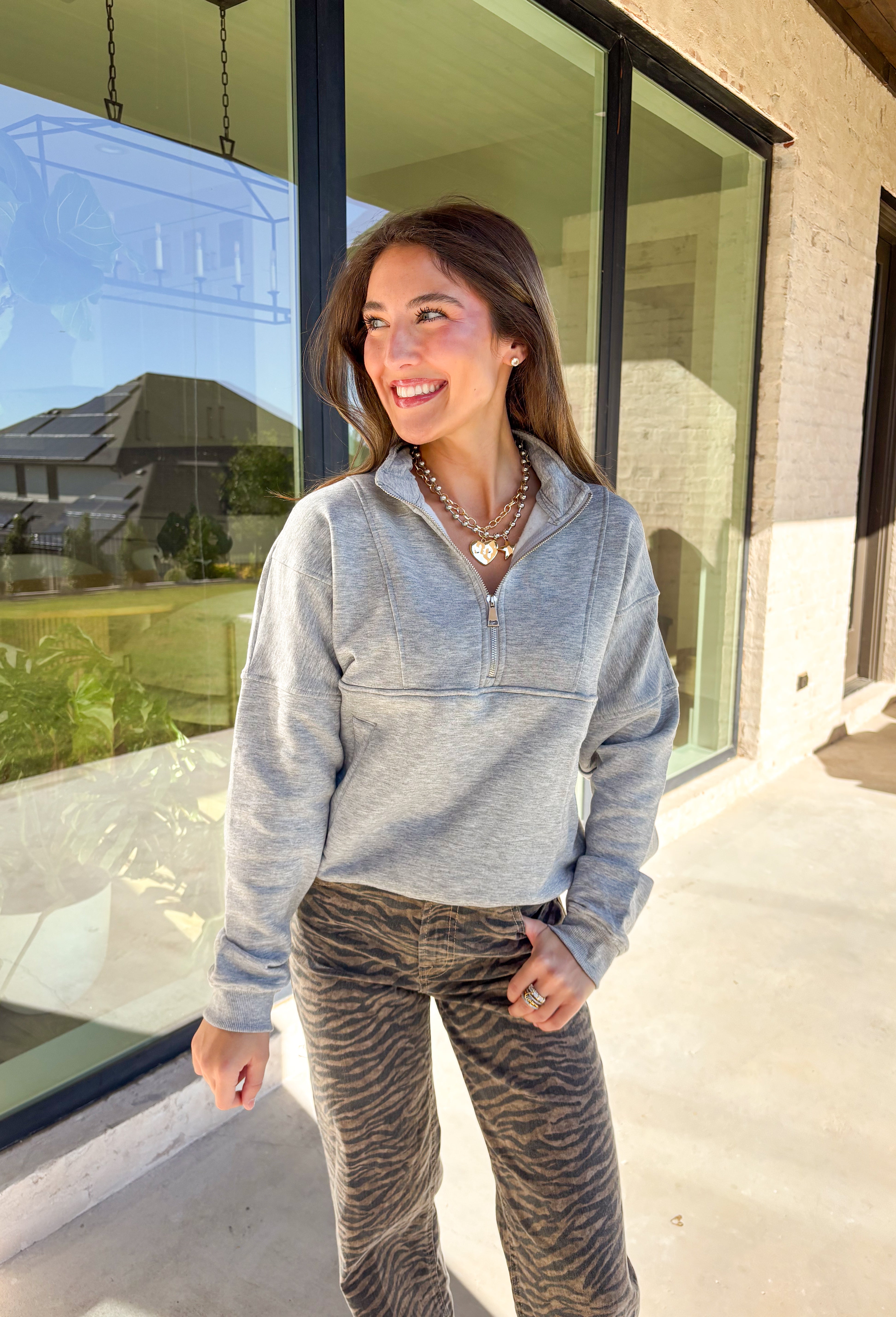 Stay warm and stylish in this heather grey quarter zip pullover by Iris. Designed with a soft fleece lining, it’s as cozy as it looks. The quarter zip neckline adds versatility, while the two front pockets make it practical for everyday wear. With just the right amount of stretch in the fabric, this pullover is perfect for lounging, layering, or running errands in comfort.&nbsp;