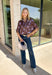Rich fall shades and standout details make this printed blouse from Entro an easy way to bring a little color into your autumn wardrobe. The warm brown base is accented with lilac and dark purple throughout, creating a unique print that pairs beautifully with the season’s deeper tones. A classic shirt collar and hammered gold buttons dress up the front, while the ¾ dolman sleeves give it a relaxed, comfortable silhouette. 