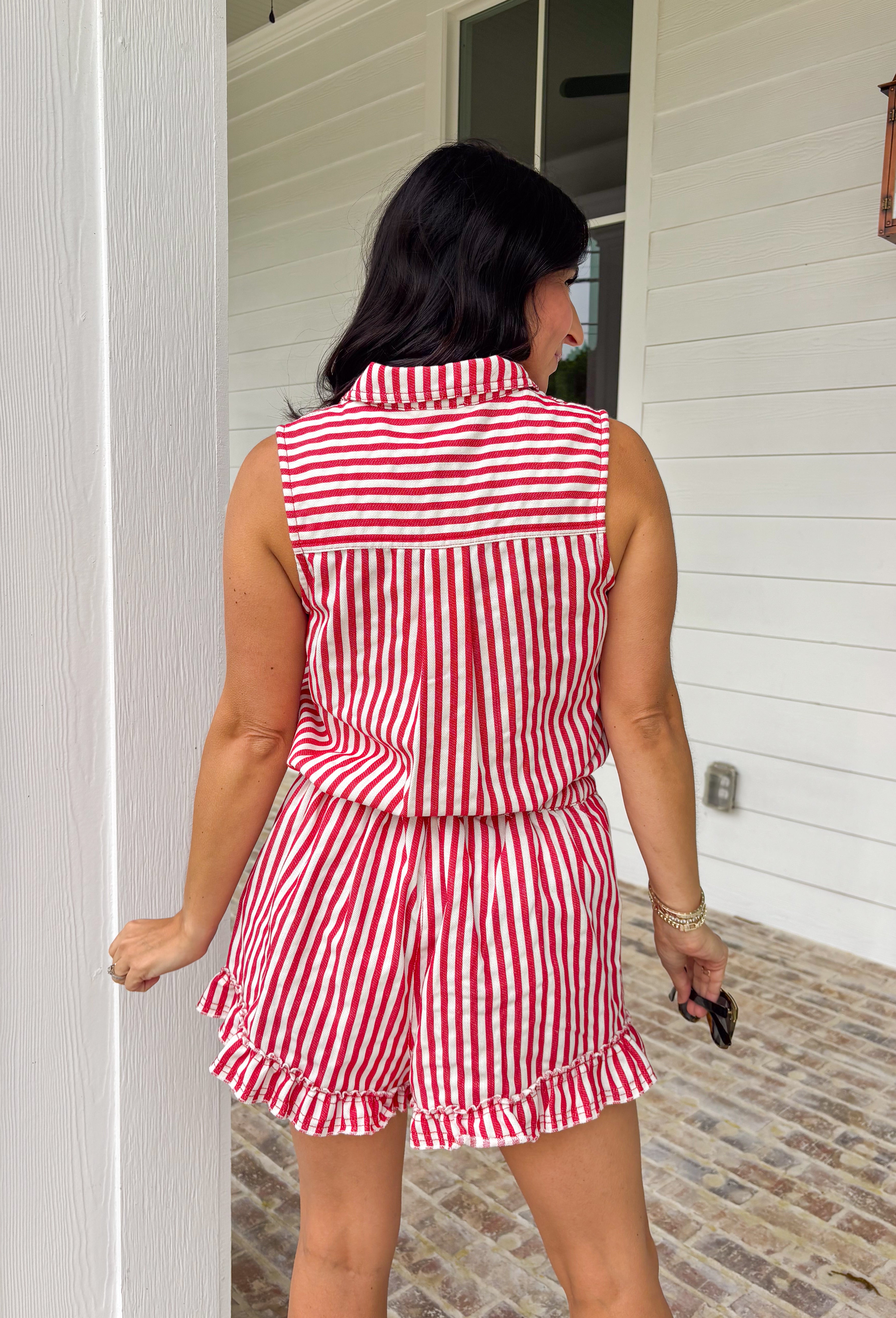 Meet your go-to romper for sunny days and festive celebrations. This red and white striped sleeveless romper is giving effortless summer charm with a playful, patriotic twist—perfect for the 4th of July and beyond. Designed with a collared neckline and front snap button detail, it has a polished feel while still keeping things relaxed and easy. The elastic waist with an adjustable tie creates a flattering, comfortable fit, and the chest pockets plus side pockets add that practical touch