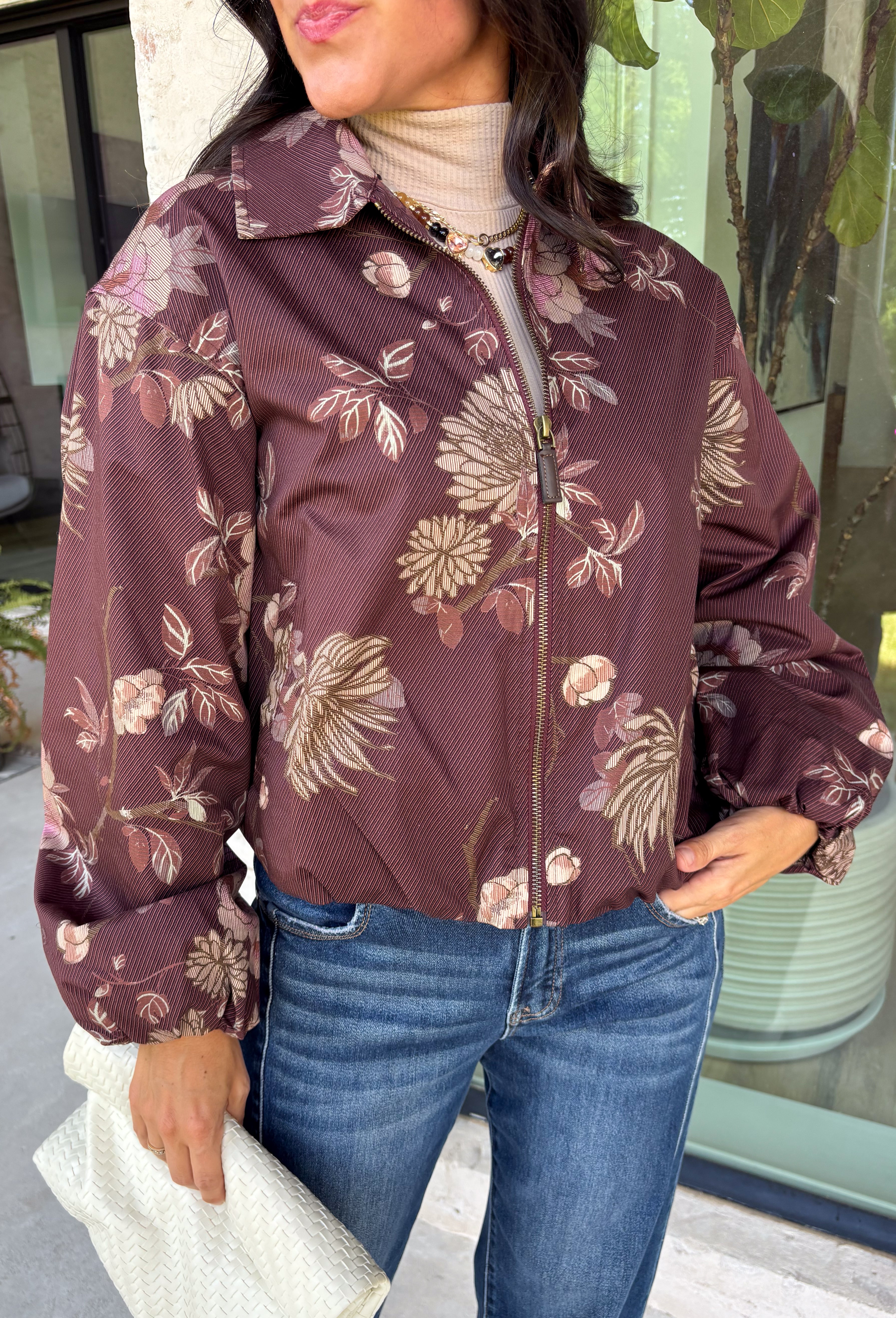 Make your fall layers a little more interesting with this deep burgundy jacket from Entro. A unique mix of stripes and neutral floral prints brings together rich autumn shades for a look that stands out while still being easy to style. The collared neckline and zipper-front closure give it a classic jacket feel, while the bubble hem adds shape and a fun, modern finish. Made from 100% cotton, it’s a great lightweight layer for those in-between fall days when you need just a little something extra. 