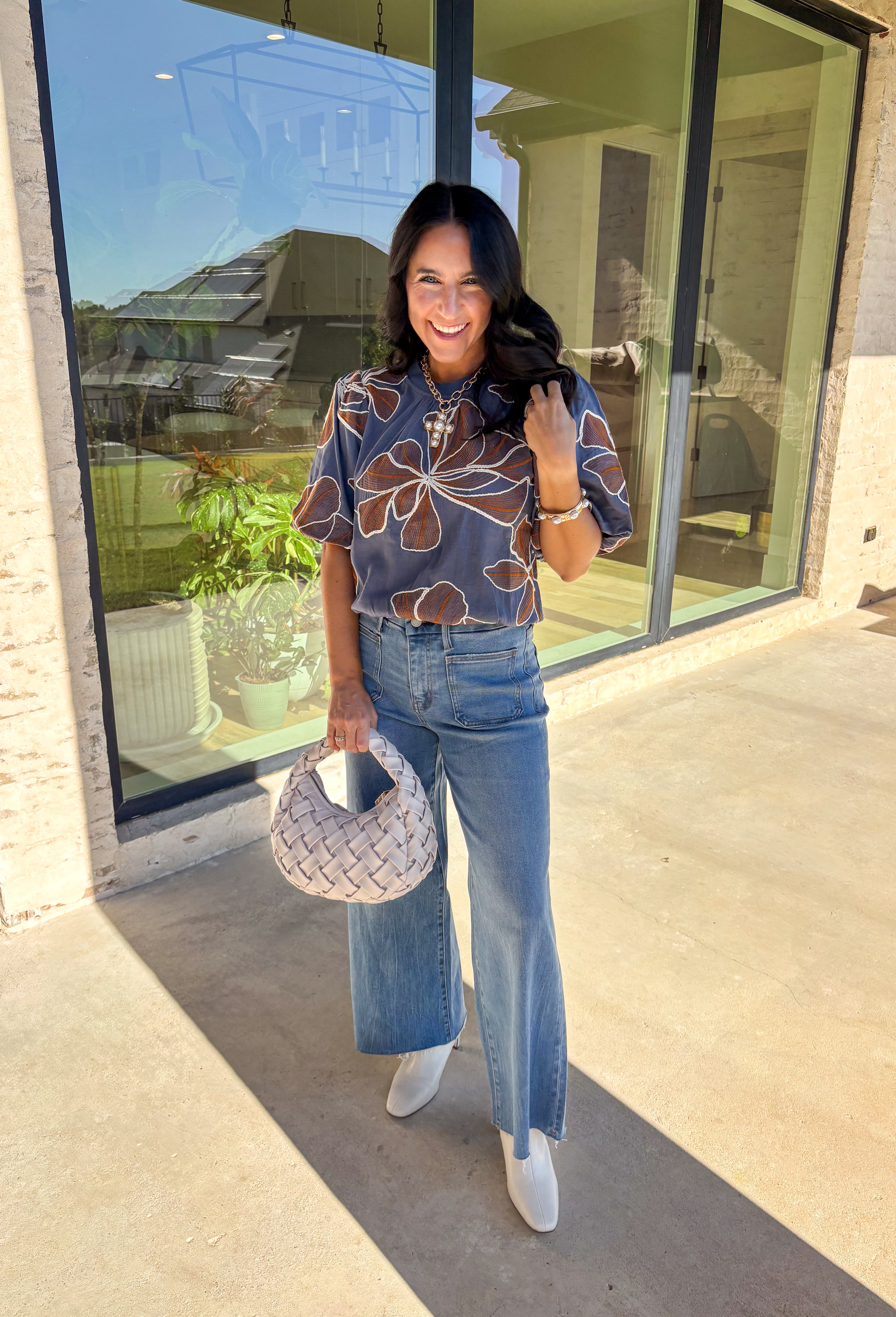 Effortlessly charming, this blue puff sleeve top by Voy is a fall favorite with a touch of whimsy. Designed with an oversized rust and white embroidered floral pattern throughout, it brings texture and color to your everyday look. The short puff sleeves and lettuce hem add a feminine finish, while the soft linen-blend fabric keeps it lightweight and breathable. Perfect for pairing with denim or skirts all season long.