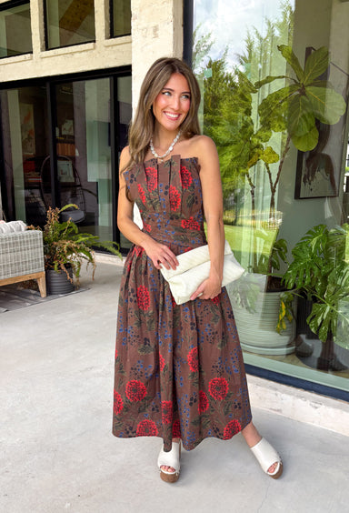 Celebrate the beauty of the season in this effortlessly feminine midi dress from Entro. Designed with a rich brown backdrop and a gorgeous floral print in warm fall-inspired shades, this timeless dress is perfect for any fall special occasion. The straight neckline and beautifully pleated bodice create an elegant, flattering silhouette, while the smocked back offers a comfortable, flexible fit. 