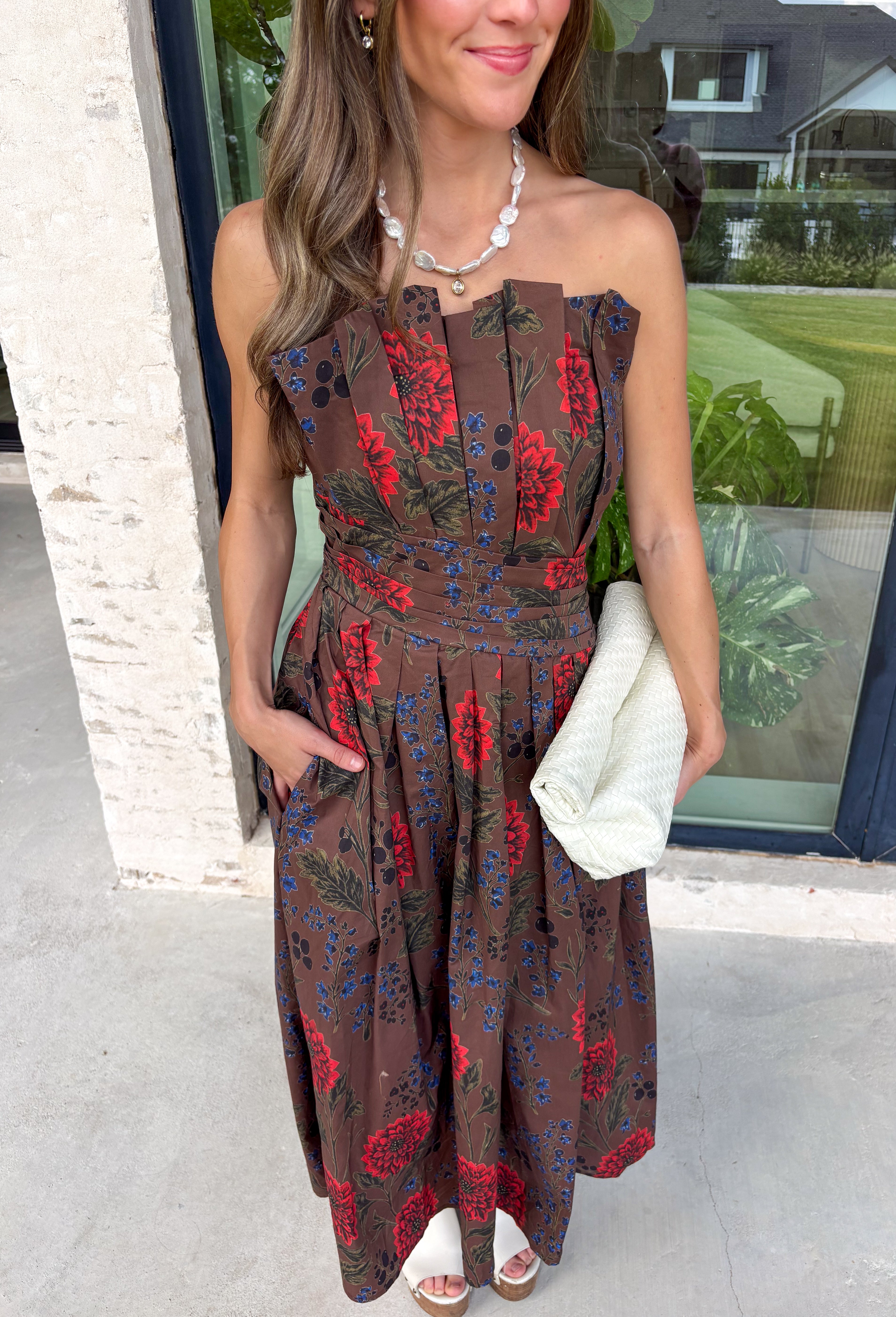 Celebrate the beauty of the season in this effortlessly feminine midi dress from Entro. Designed with a rich brown backdrop and a gorgeous floral print in warm fall-inspired shades, this timeless dress is perfect for any fall special occasion. The straight neckline and beautifully pleated bodice create an elegant, flattering silhouette, while the smocked back offers a comfortable, flexible fit. 