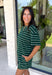 Comfort meets effortless style in this hunter green striped tee. Featuring a timeless white stripe print, this soft tee is the perfect piece to take you from laid-back weekends to busy weekdays with ease. Wear it with the matching shorts for a coordinated set that's equal parts cozy and stylish, or mix and match it with your favorite denim, or leggings, for endless outfit options. 