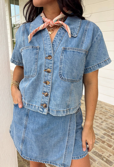 This medium wash button down denim top is one of those pieces you’ll keep reaching for all spring long! Made from 100% cotton, it’s lightweight, breathable, and perfect for layering or wearing on its own. The classic collared neckline and front pockets give it that timeless, easygoing feel, while the medium wash makes it endlessly versatile. Pair it with the matching skort for a matching set, or throw it on with white denim, skirts, —it’s the ultimate grab-and-go staple for busy days.