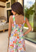 Say hello to your new one-and-done spring outfit! This white jumpsuit is covered in the prettiest colorful floral print with pops of green, orange, purple, pink, and yellow—basically sunshine in clothing form. The square neckline gives it a clean, flattering shape, while the smocked back keeps it comfy and flexible. Finished with side pockets (yes please), a side zipper for easy on-and-off, and adjustable ties at the waist and ankles, this piece is made for everything from weekend plans to vacation days.