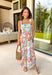 Say hello to your new one-and-done spring outfit! This white jumpsuit is covered in the prettiest colorful floral print with pops of green, orange, purple, pink, and yellow—basically sunshine in clothing form. The square neckline gives it a clean, flattering shape, while the smocked back keeps it comfy and flexible. Finished with side pockets (yes please), a side zipper for easy on-and-off, and adjustable ties at the waist and ankles, this piece is made for everything from weekend plans to vacation days.