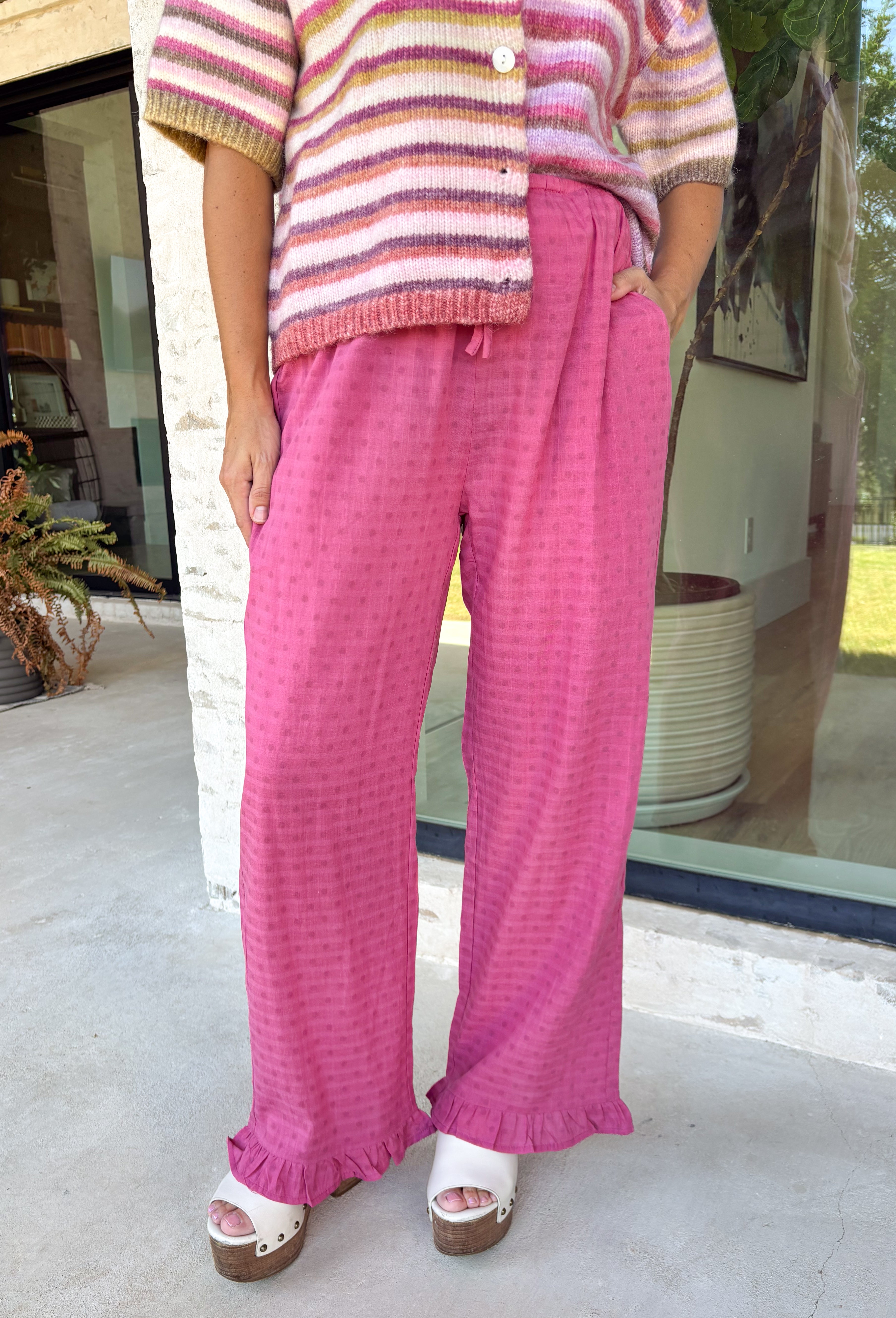 A playful pink palette gives these pants from Twentifourth plenty of personality while still keeping them easy to style. The subtle monochromatic polka dot print adds a fun touch of texture without overpowering the look, while the ruffle hem gives the relaxed silhouette a sweet finishing detail. An elastic waistband with a drawstring keeps them comfortable for all-day wear, and side and back pockets add everyday function. 