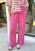 A playful pink palette gives these pants from Twentifourth plenty of personality while still keeping them easy to style. The subtle monochromatic polka dot print adds a fun touch of texture without overpowering the look, while the ruffle hem gives the relaxed silhouette a sweet finishing detail. An elastic waistband with a drawstring keeps them comfortable for all-day wear, and side and back pockets add everyday function. 