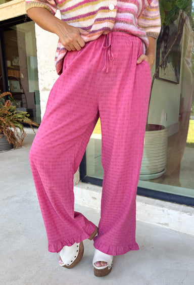 A playful pink palette gives these pants from Twentifourth plenty of personality while still keeping them easy to style. The subtle monochromatic polka dot print adds a fun touch of texture without overpowering the look, while the ruffle hem gives the relaxed silhouette a sweet finishing detail. An elastic waistband with a drawstring keeps them comfortable for all-day wear, and side and back pockets add everyday function. 
