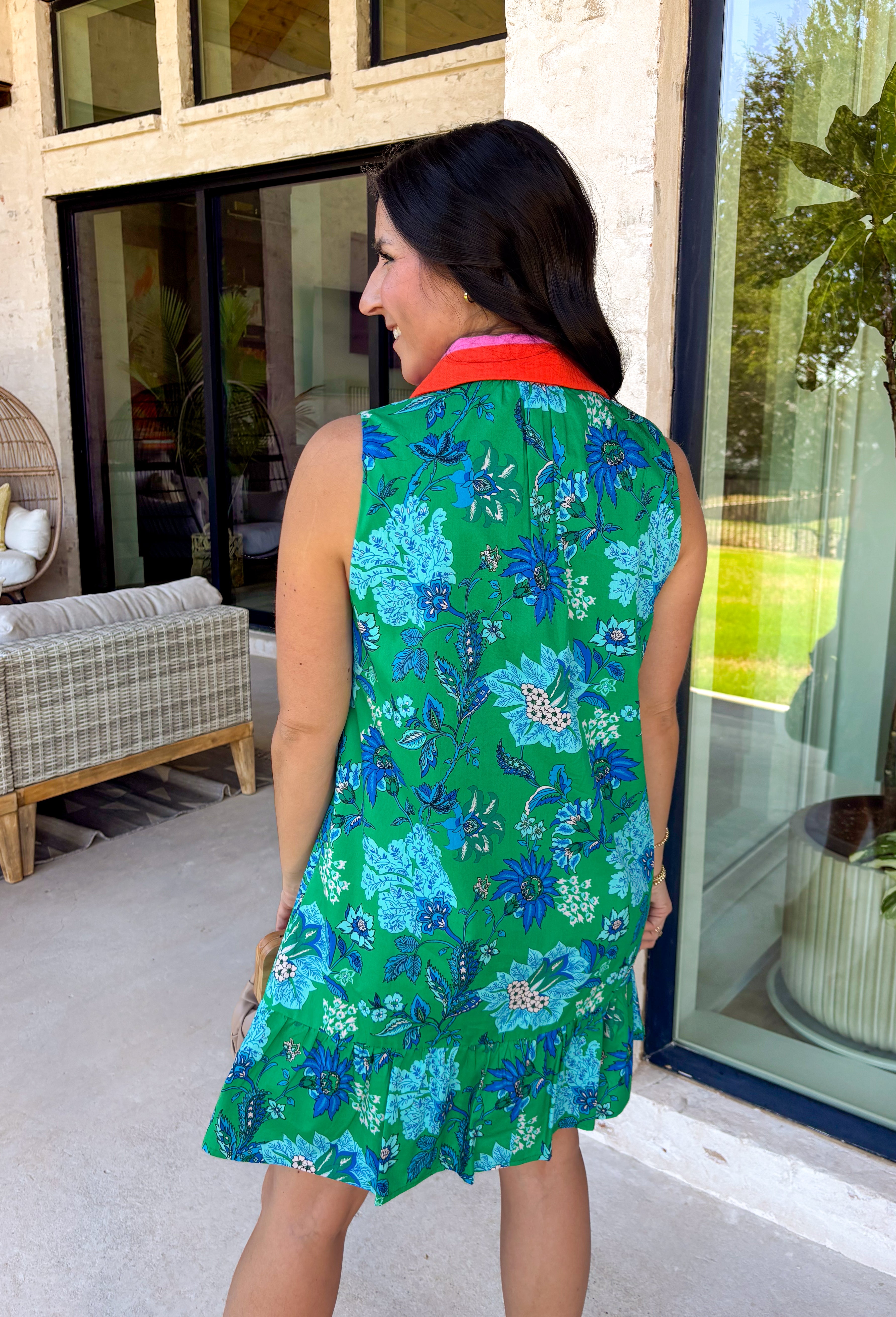 Fresh, vibrant, and made for sunny days, this sleeveless green dress is blooming with a beautiful blue floral print that instantly brightens your look. The pink and tomato red contrast trim along the collared neckline and along the front adds a playful pop of color that makes this piece feel extra special. It’s the kind of dress you’ll reach for when you want something easy, flattering, and full of personality.