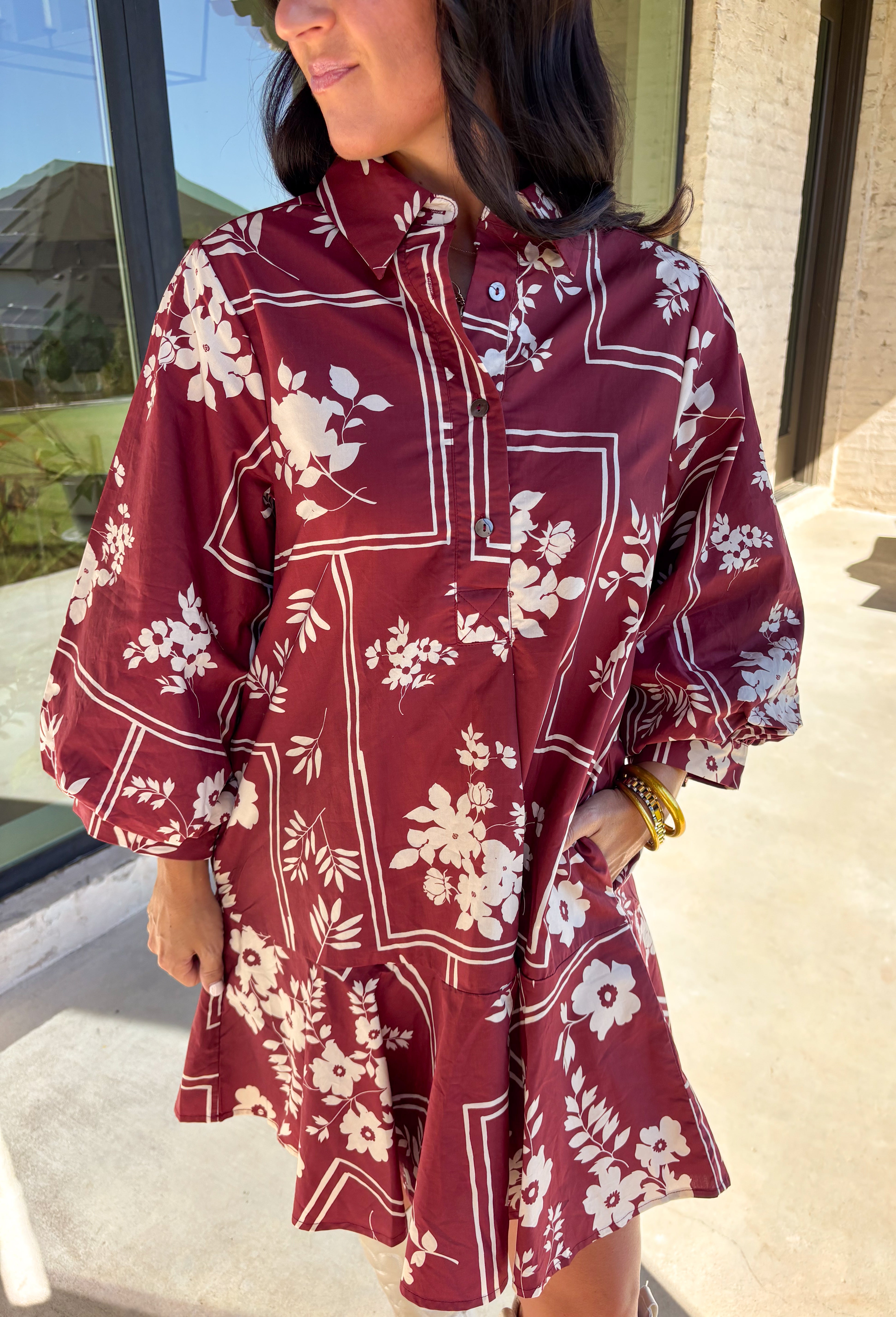 Effortless and feminine, this brick red dress is blooming with white botanical florals for a timeless autumn look. Featuring ¾ sleeves and a button-front closure, it blends comfort with charm. Side pockets add a touch of practicality, while the ruffle-free silhouette keeps it simple and chic. Fully lined and made from breathable cotton, this is the kind of dress you’ll love to style for everyday wear or seasonal gatherings.