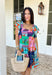 This light blue dress is bringing all the tropical energy in the prettiest way. Featuring a colorful abstract print with pops of green, navy, orange, and pink, it feels fresh, vibrant, and ready for sunshine. The square neckline adds a flattering, modern touch, while the elastic sleeves give it that soft, feminine shape we love. A smocked back ensures a comfortable, flexible fit, and the fully lined design keeps it easy to wear all day long. 