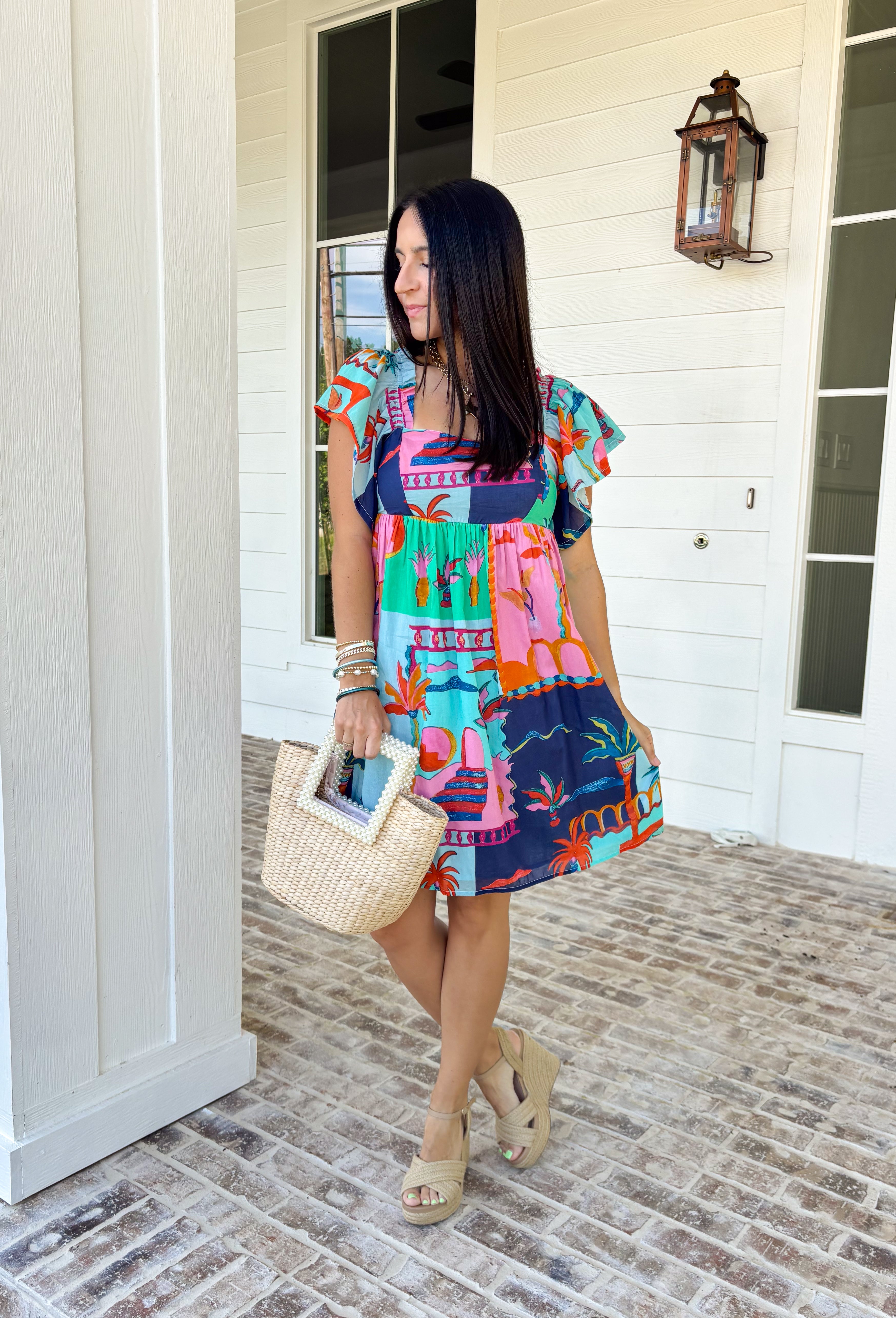 This light blue dress is bringing all the tropical energy in the prettiest way. Featuring a colorful abstract print with pops of green, navy, orange, and pink, it feels fresh, vibrant, and ready for sunshine. The square neckline adds a flattering, modern touch, while the elastic sleeves give it that soft, feminine shape we love. A smocked back ensures a comfortable, flexible fit, and the fully lined design keeps it easy to wear all day long. 