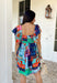 This light blue dress is bringing all the tropical energy in the prettiest way. Featuring a colorful abstract print with pops of green, navy, orange, and pink, it feels fresh, vibrant, and ready for sunshine. The square neckline adds a flattering, modern touch, while the elastic sleeves give it that soft, feminine shape we love. A smocked back ensures a comfortable, flexible fit, and the fully lined design keeps it easy to wear all day long. 