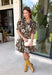 Warm autumn shades make this floral dress from Entro an easy pick for all your fall plans. The rich brown background is paired with a neutral floral print, creating a seasonal look that works beautifully for family photos, brunch, church, and weekend gatherings. A classic shirt collar and button-front closure give it a put-together feel, while short puff sleeves add just the right amount of shape. Pleated detailing at the back brings an unexpected touch to the silhouette.