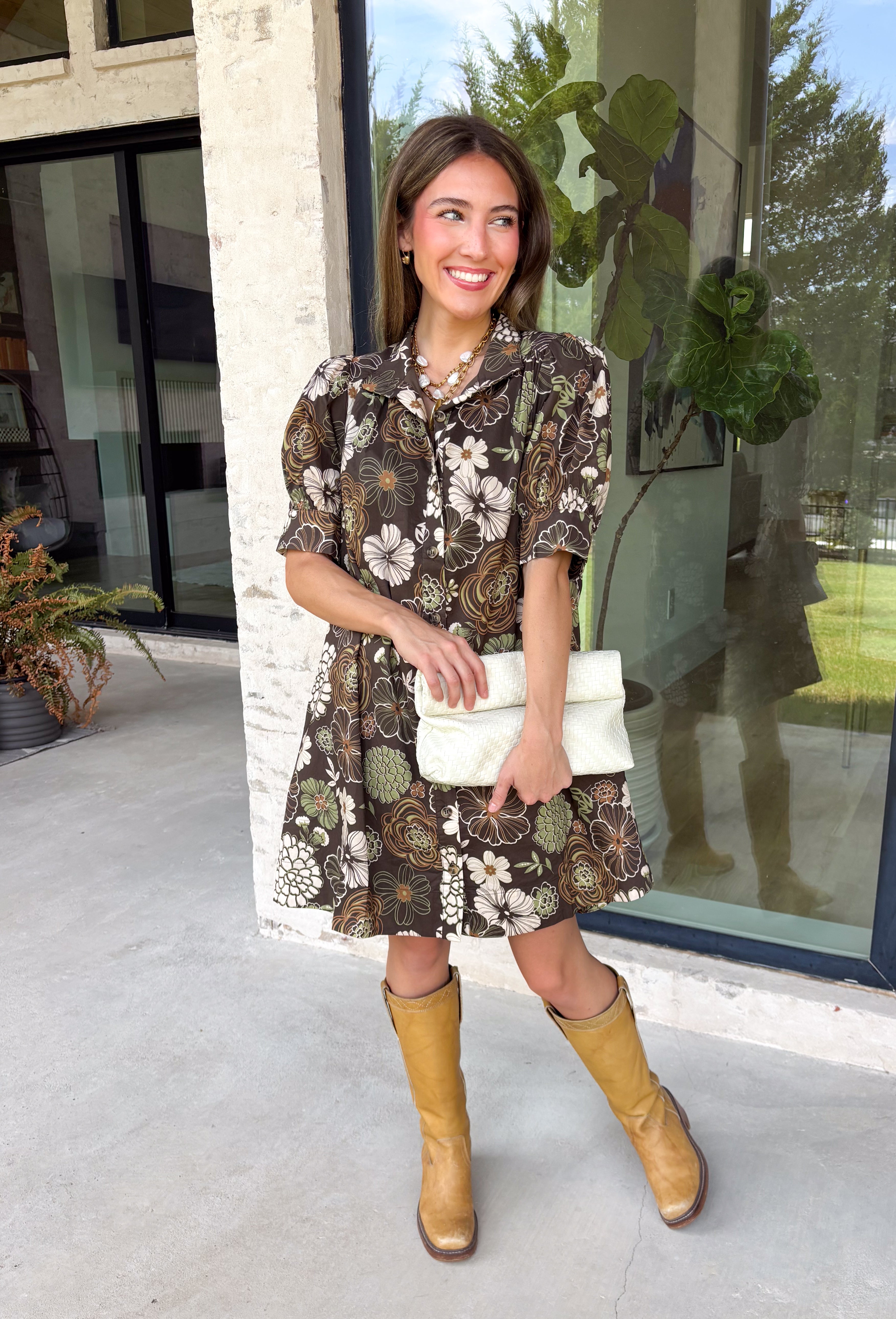 Warm autumn shades make this floral dress from Entro an easy pick for all your fall plans. The rich brown background is paired with a neutral floral print, creating a seasonal look that works beautifully for family photos, brunch, church, and weekend gatherings. A classic shirt collar and button-front closure give it a put-together feel, while short puff sleeves add just the right amount of shape. Pleated detailing at the back brings an unexpected touch to the silhouette.
