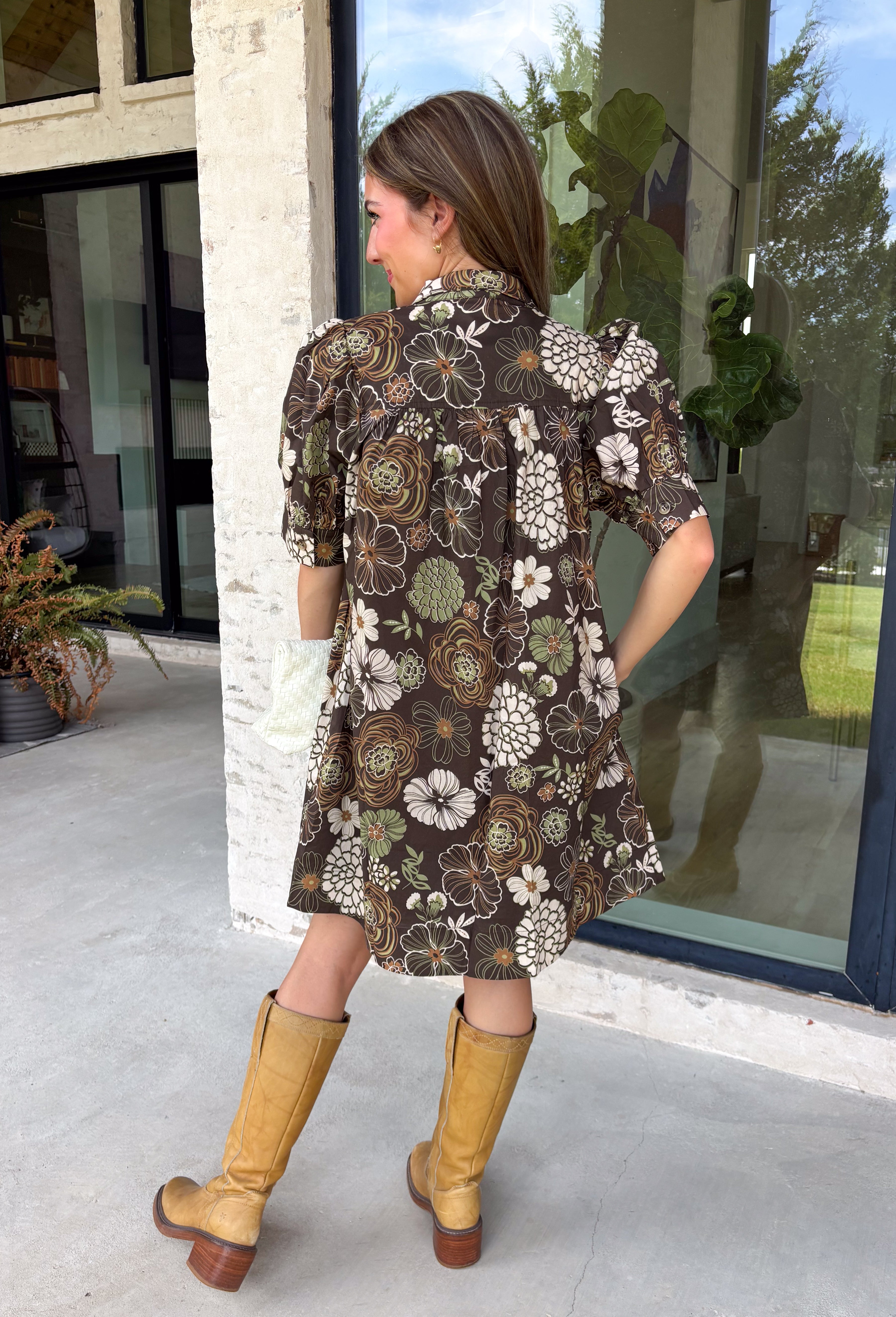 Warm autumn shades make this floral dress from Entro an easy pick for all your fall plans. The rich brown background is paired with a neutral floral print, creating a seasonal look that works beautifully for family photos, brunch, church, and weekend gatherings. A classic shirt collar and button-front closure give it a put-together feel, while short puff sleeves add just the right amount of shape. Pleated detailing at the back brings an unexpected touch to the silhouette.