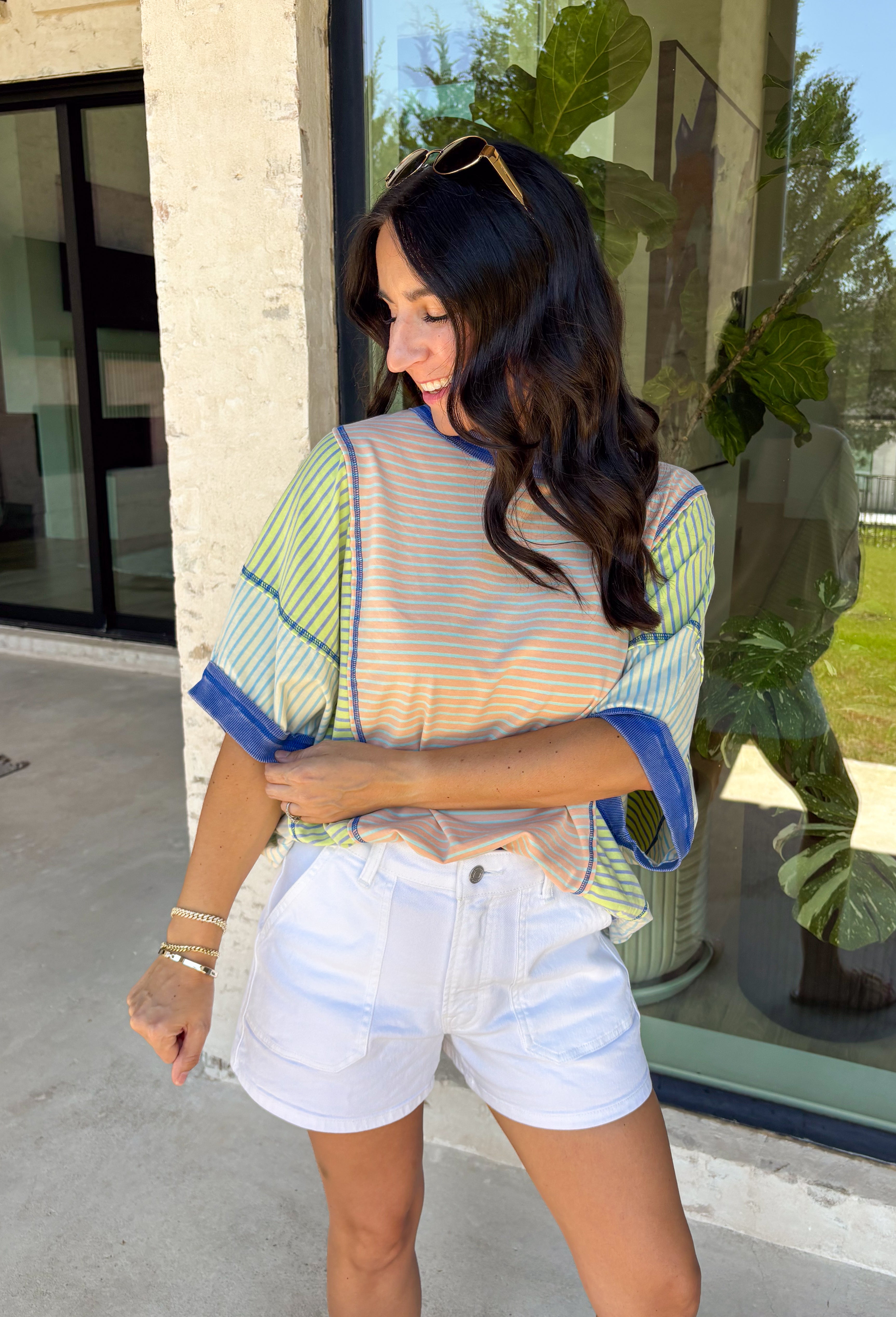This color block stripe top is the perfect mix of laid-back and fun for summer! With shades of coral, tan, green, and blue, it brings a fresh pop of color while still feeling easy to style. The dark blue threading throughout adds a subtle contrast that pulls everything together, and the dolman sleeves give it that relaxed, effortless fit. Soft, stretchy, and breathable, it’s perfect for busy days when you want to feel comfortable but still put together. 