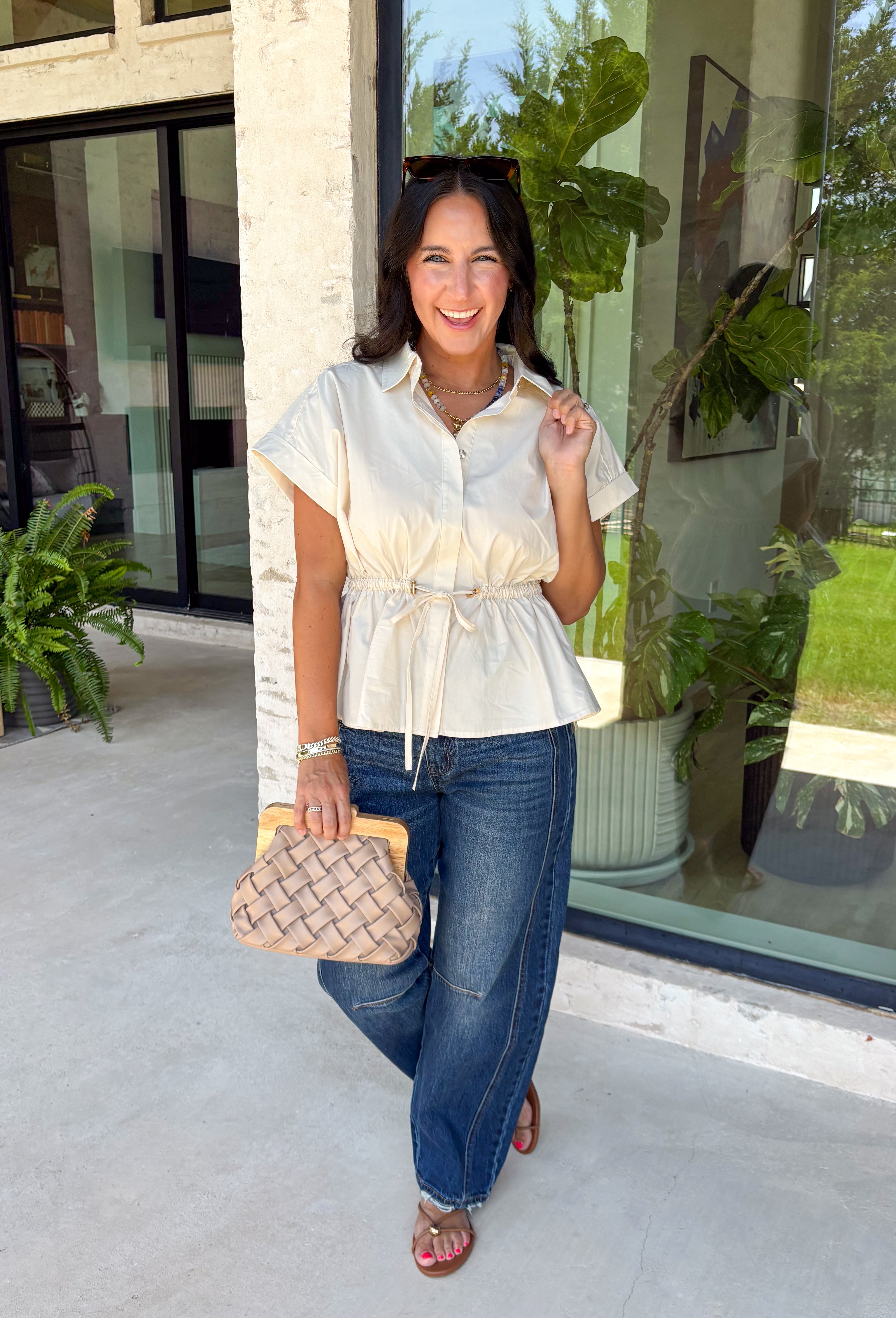 A timeless neutral top is one of the best investments for your fall wardrobe! This off white cotton blouse combines classic details with a flattering silhouette you'll love wearing on repeat. The collared neckline and button front create a polished look, while the elastic drawstring waist cinches just right for a feminine shape. Finished with a peplum hem and cap sleeves, it's the perfect blend of comfortable and elevated. 