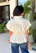 A timeless neutral top is one of the best investments for your fall wardrobe! This off white cotton blouse combines classic details with a flattering silhouette you'll love wearing on repeat. The collared neckline and button front create a polished look, while the elastic drawstring waist cinches just right for a feminine shape. Finished with a peplum hem and cap sleeves, it's the perfect blend of comfortable and elevated. 