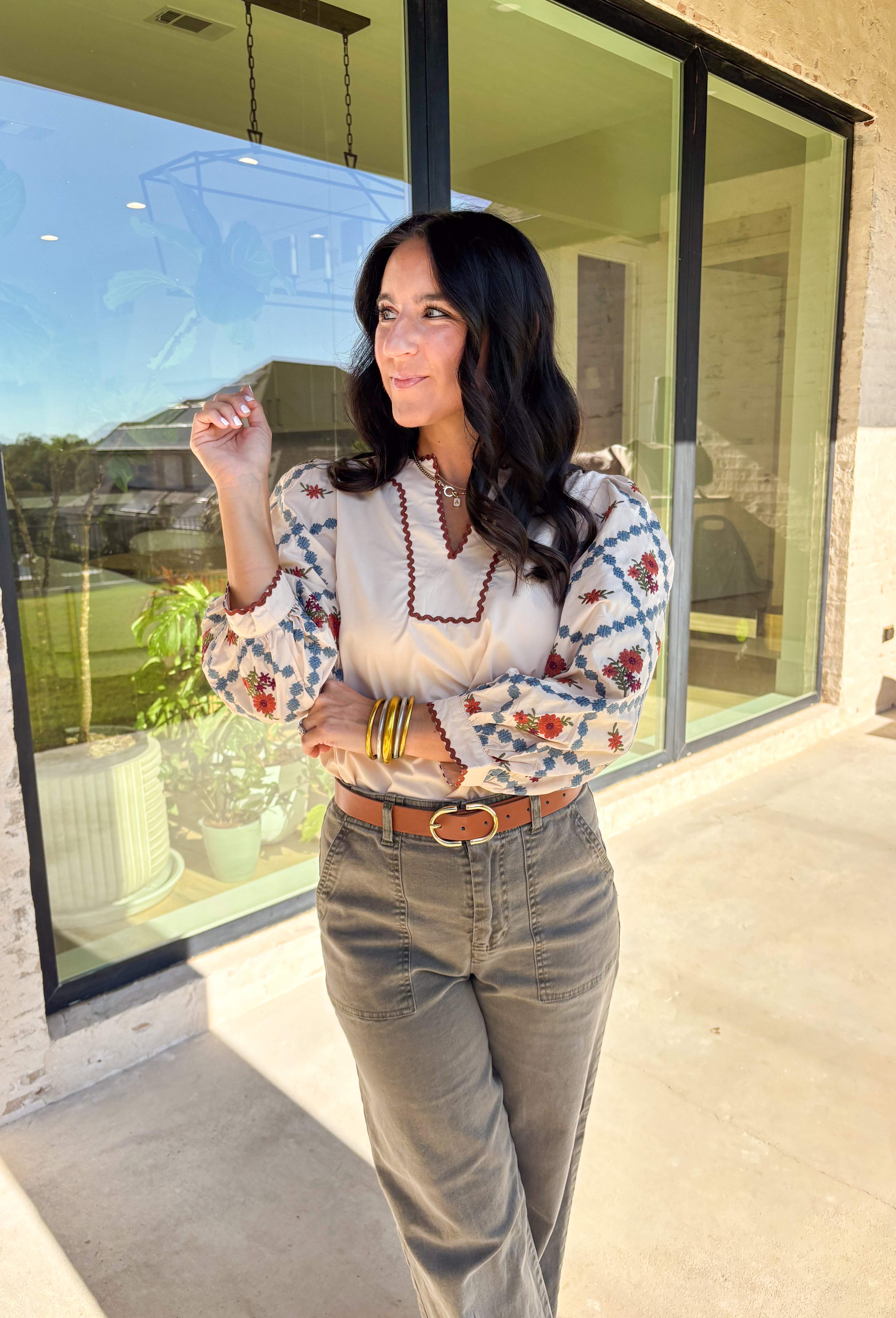 This ecru long sleeve top by Entro brings an elegant touch to your fall wardrobe with its beautifully embroidered floral sleeves. Detailed in shades of burgundy, rust, blue, and green, the embroidery stands out perfectly against the soft neutral base. The contrast scallop trim neckline adds a sweet finishing touch, giving this pullover top a timeless and feminine feel. Lightweight and easy to style, it’s a lovely go-to piece for both casual days and dressed-up outings.