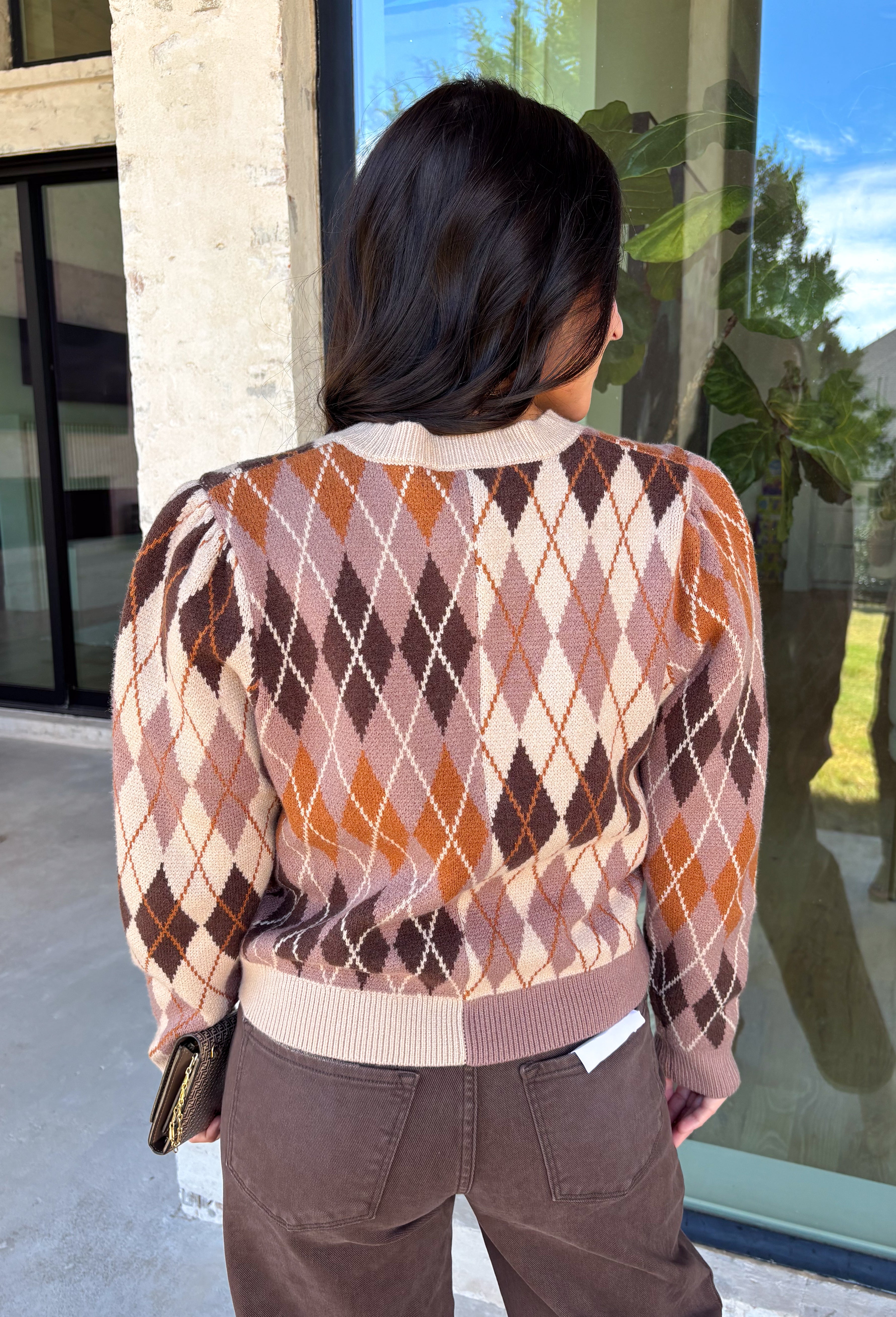 Classic patterns never go out of style, and this beautiful cardigan from THML is the perfect example. Designed with a timeless tan and brown argyle pattern, this cozy knit is finished with elegant gold buttons that add a polished touch. The neutral color palette makes it effortless to pair with everything in your wardrobe, while the ribbed neckline, cuffs, and hem create a refined finish. 
