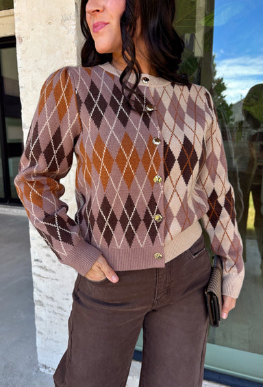 Classic patterns never go out of style, and this beautiful cardigan from THML is the perfect example. Designed with a timeless tan and brown argyle pattern, this cozy knit is finished with elegant gold buttons that add a polished touch. The neutral color palette makes it effortless to pair with everything in your wardrobe, while the ribbed neckline, cuffs, and hem create a refined finish. 
